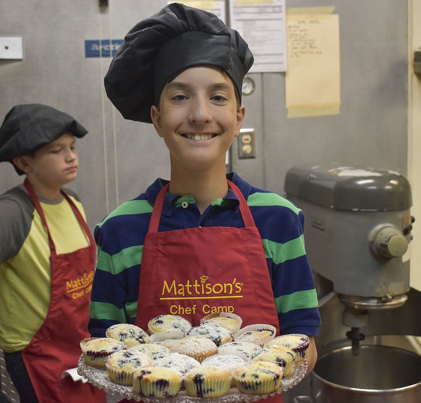 Patrick Van Eyck shows off the blueberry muffins that he just dusted with powder sugar.