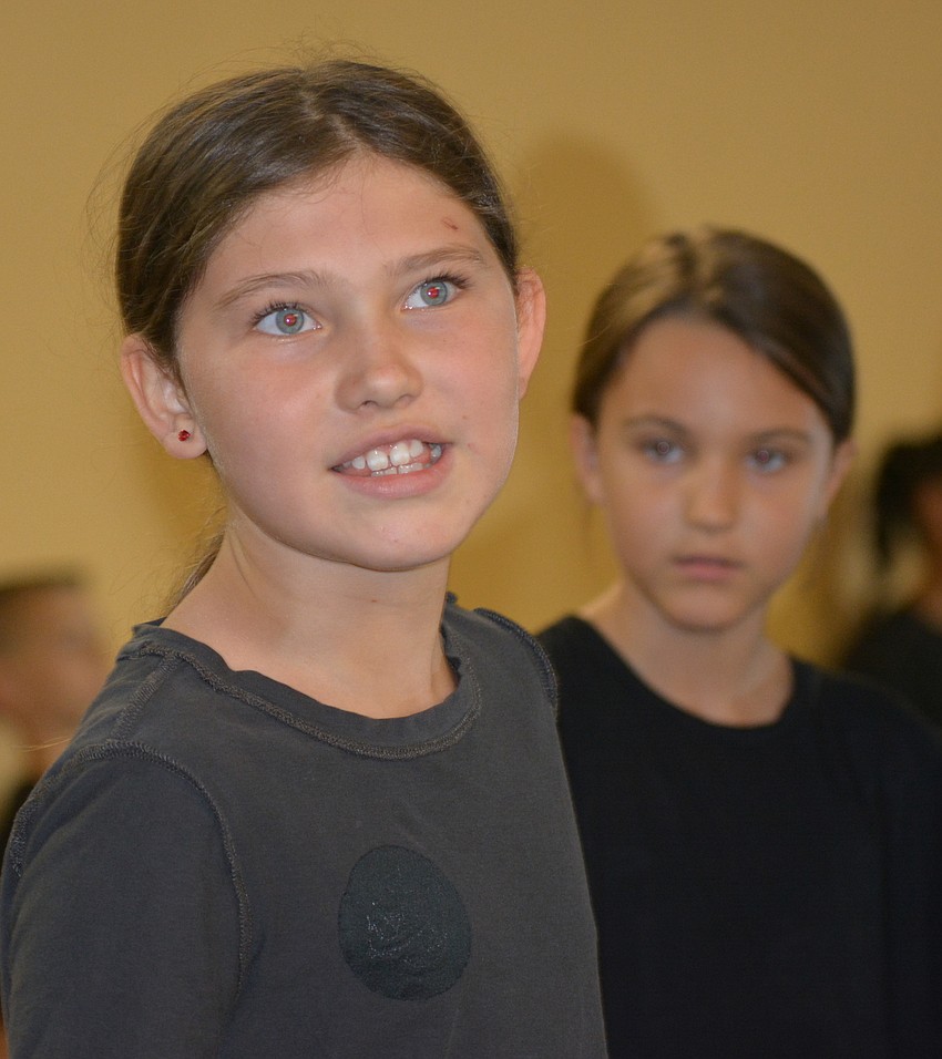 Zoe Howard performs with ,Zoe Motzenbecker in the background.