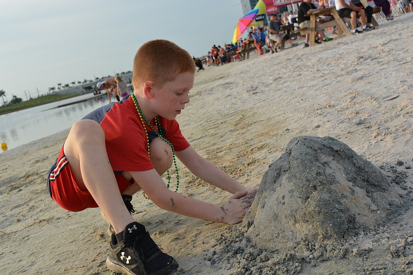 Nine-year-old Trae Tucker, of Port Charlotte, builds a sand volcano before the fireworks.