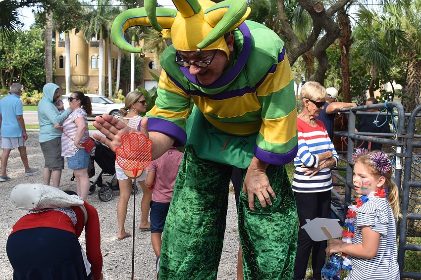 Aaron Watkins leans down from his stilts for a high five.