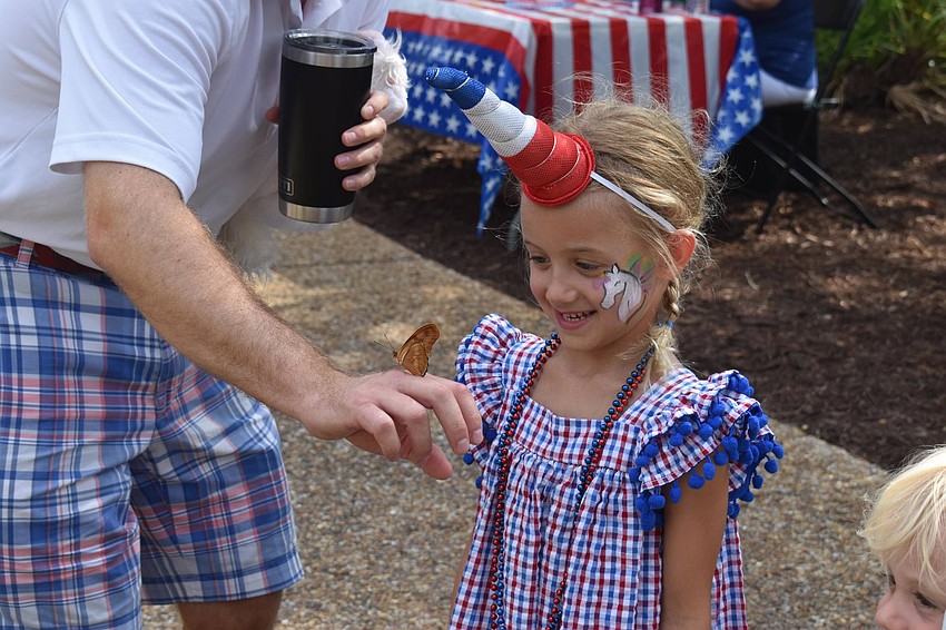Maryellen Forshey looks on as her dad, Alex Forshey, holds a butterfly.