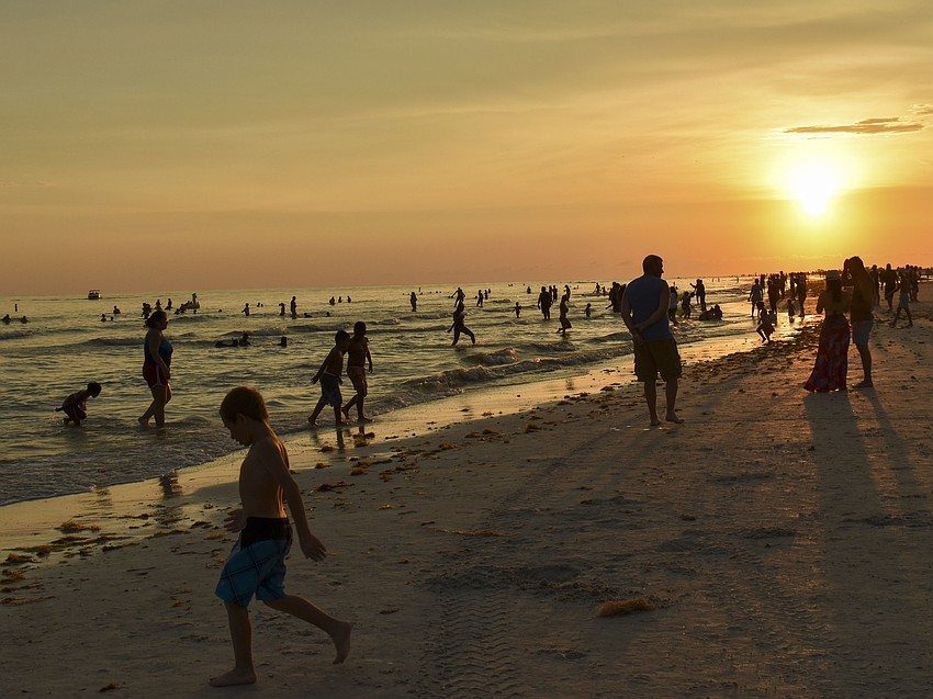 Beachgoers hang out in the water before the fireworks begin.
