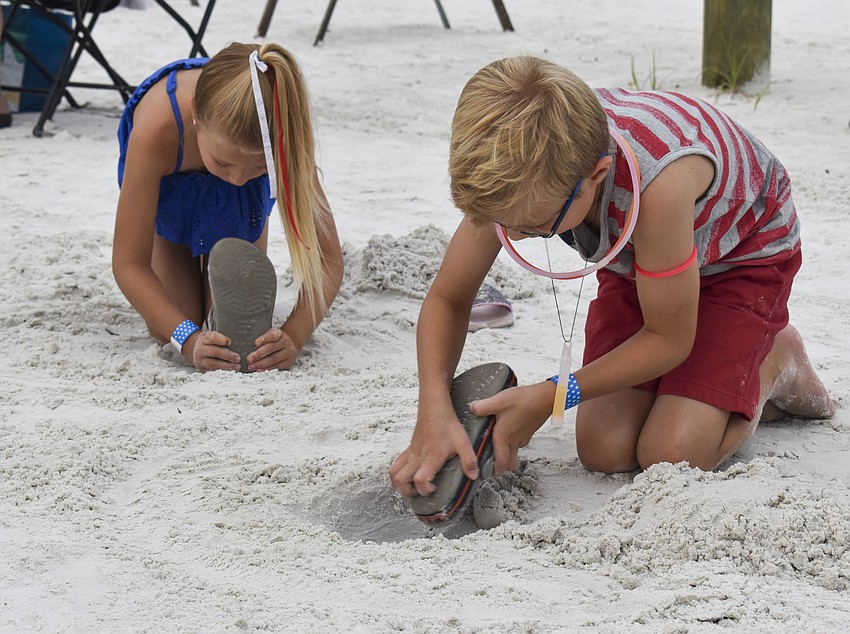 Ashely and Josh Eisenacher play in the sand before the fireworks begin.