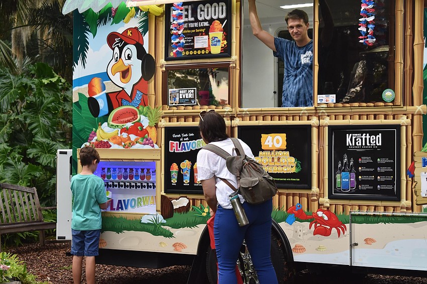 Liz and Finnegan Gray prepare to cool down with shaved ice served by Joe McVicker.