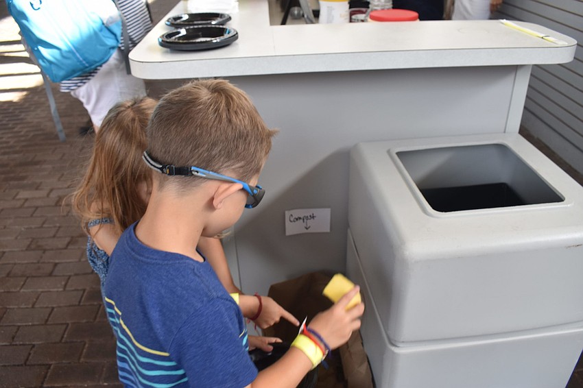 Camden and Jane Walters sort their trash from breakfast, throwing the banana peel into the compost bag.
