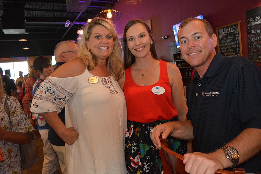 Willis A. Smith Construction's Peggy Kronus joins Jenn Otterness and co-worker Austin Bella for beer and wine.