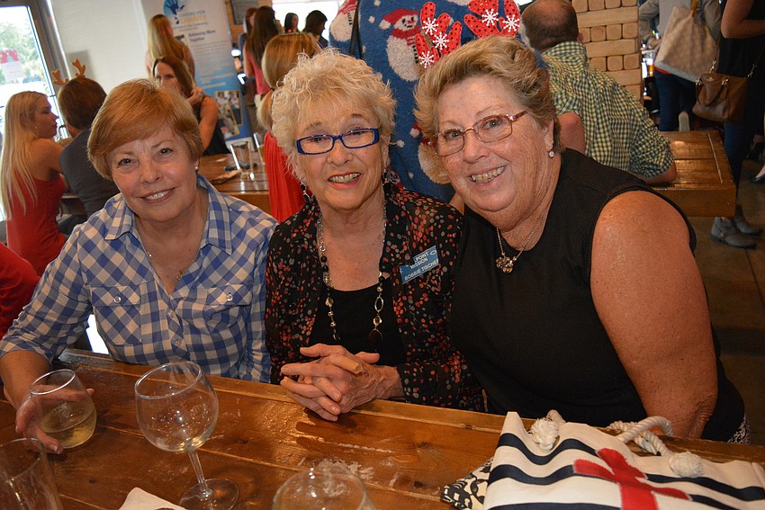 Stillpoint Mission volunteers Bobbi Wagner, Bobbie Tischer and Kae Nekuza feast on pretzels and wine as they chat.
