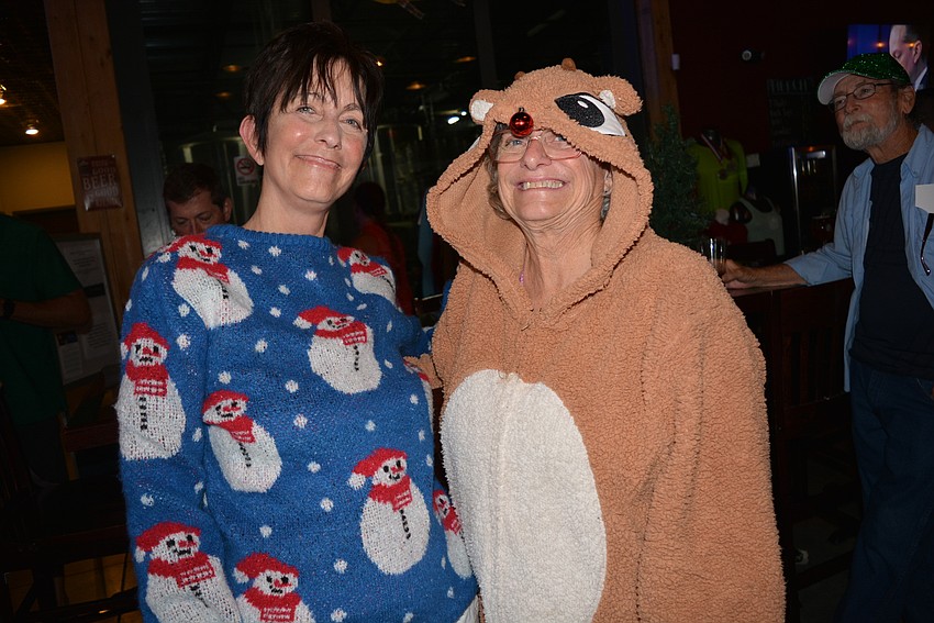 Realize Bradenton Director Johnette Isham poses with Realize Bradenton's farmer's market manager Peg Haynes, who borrowed a reindeer costume from a friend. Realize Bradenton was a beneficiary of the evening.