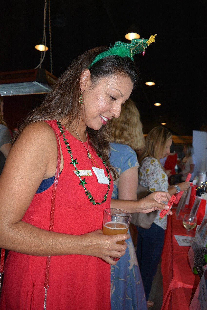 Lakewood Ranch Moms Group member Melanie Hayes looks over the silent raffle items, opting for gift cards.