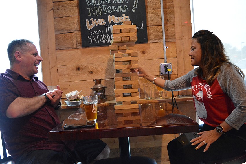 Lakewood Ranch's Dave Fischer and Janet Reyes challenge each other to a game of Jenga. Both donated items for the raffle fundraiser.