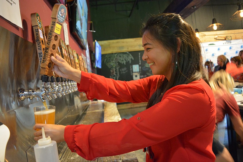 Cheers for Charity member Marissa Bressi fills up a beer for guests. Members helped raise money by bartending for the evening.