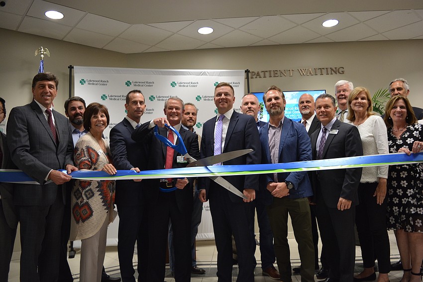 Hospital officials, contractors and others celebrate the grand opening with a ribbon cutting ceremony.