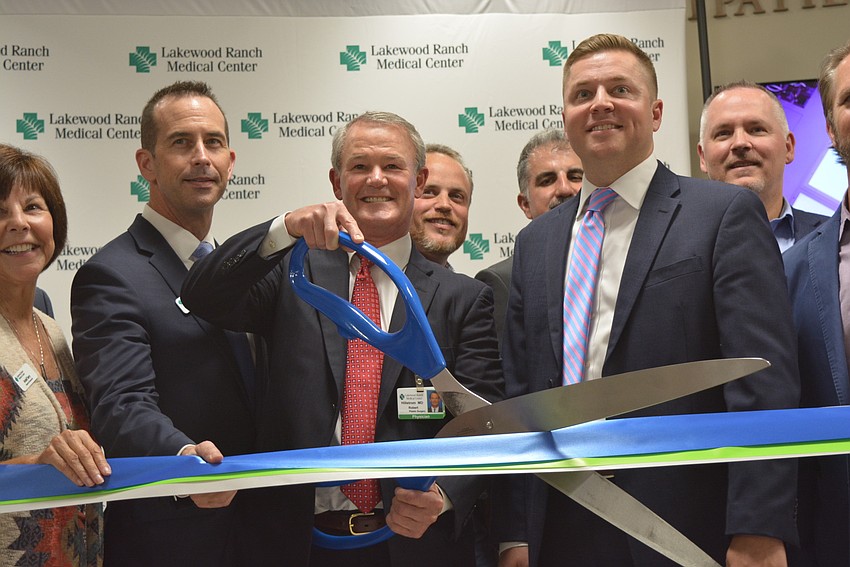 In front: Hospital board member Bryan Boudreaux, Hospital Board Chairman Dr. Robert Hillstrom and Lakewood Ranch Medical Center CEO Andy Guz participate in the ribbon cutting ceremony.