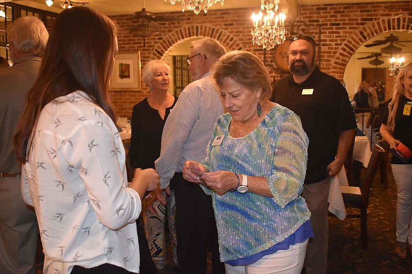 Gail Loefgren hands out her card at the event.