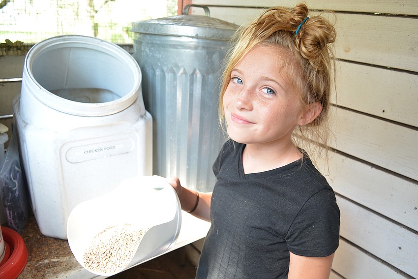 Camper Hailey Watson prefers to put fresh shavings in the horse stalls, but says feeding the chickens is 