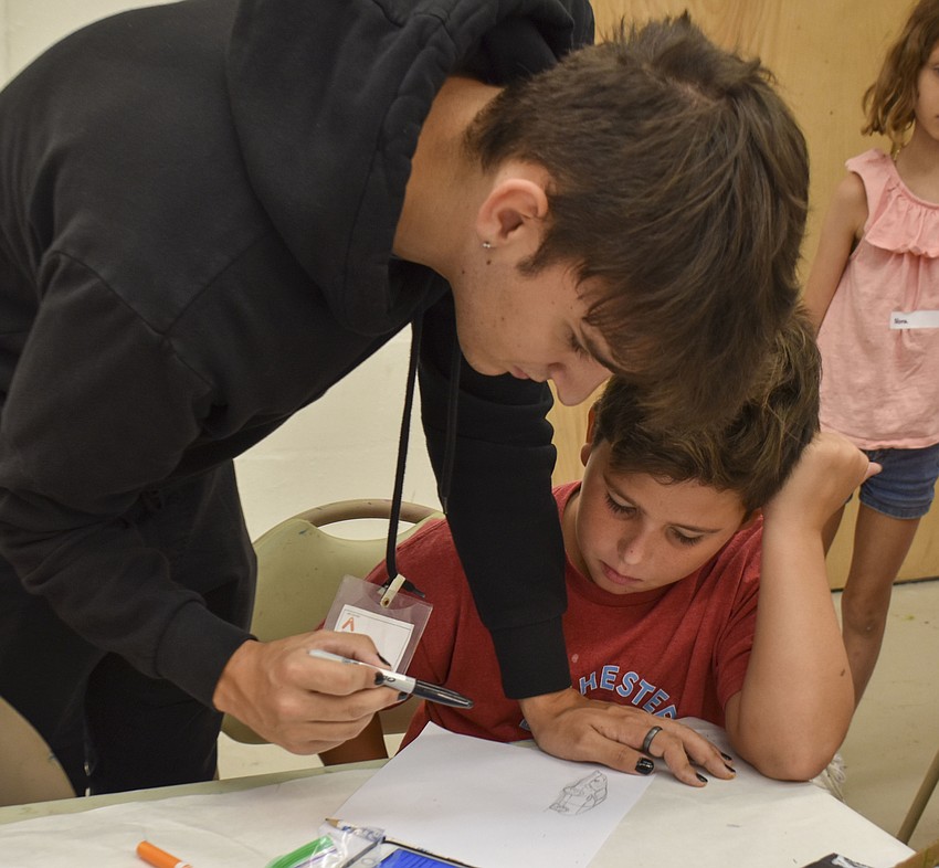 Colin Gentile, an Art Center teaching assistant, helps Brody Neal draw a Ferrari.
