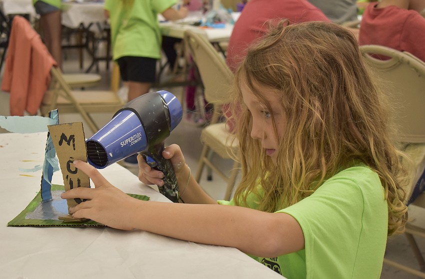 Molly Harris uses a hair dryer to speed up her projects drying process.