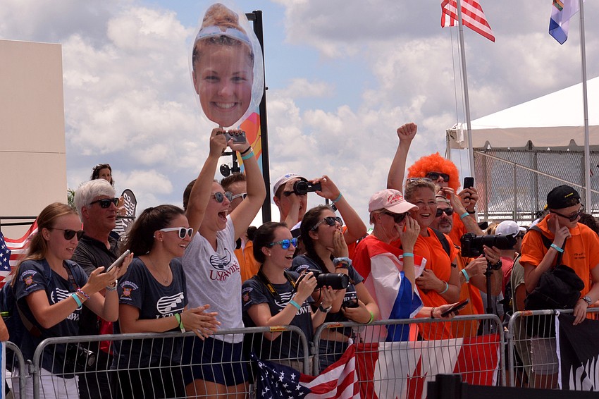 U.S. fans hold up a cutout of Sophia Kershner's head at the medal ceremony. Kershner helped the women's eight boat to a bronze medal.