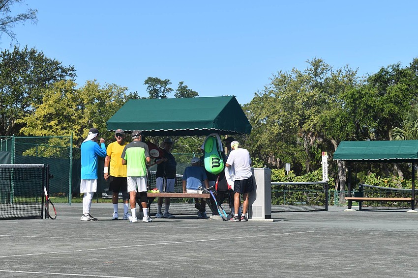 Two groups of doubles players gather for water.
