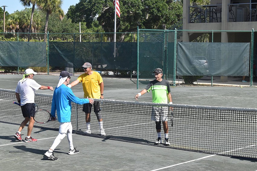 Mark Guilford and Marv Hart shake hands with Mel Tab and Enrique Vela.