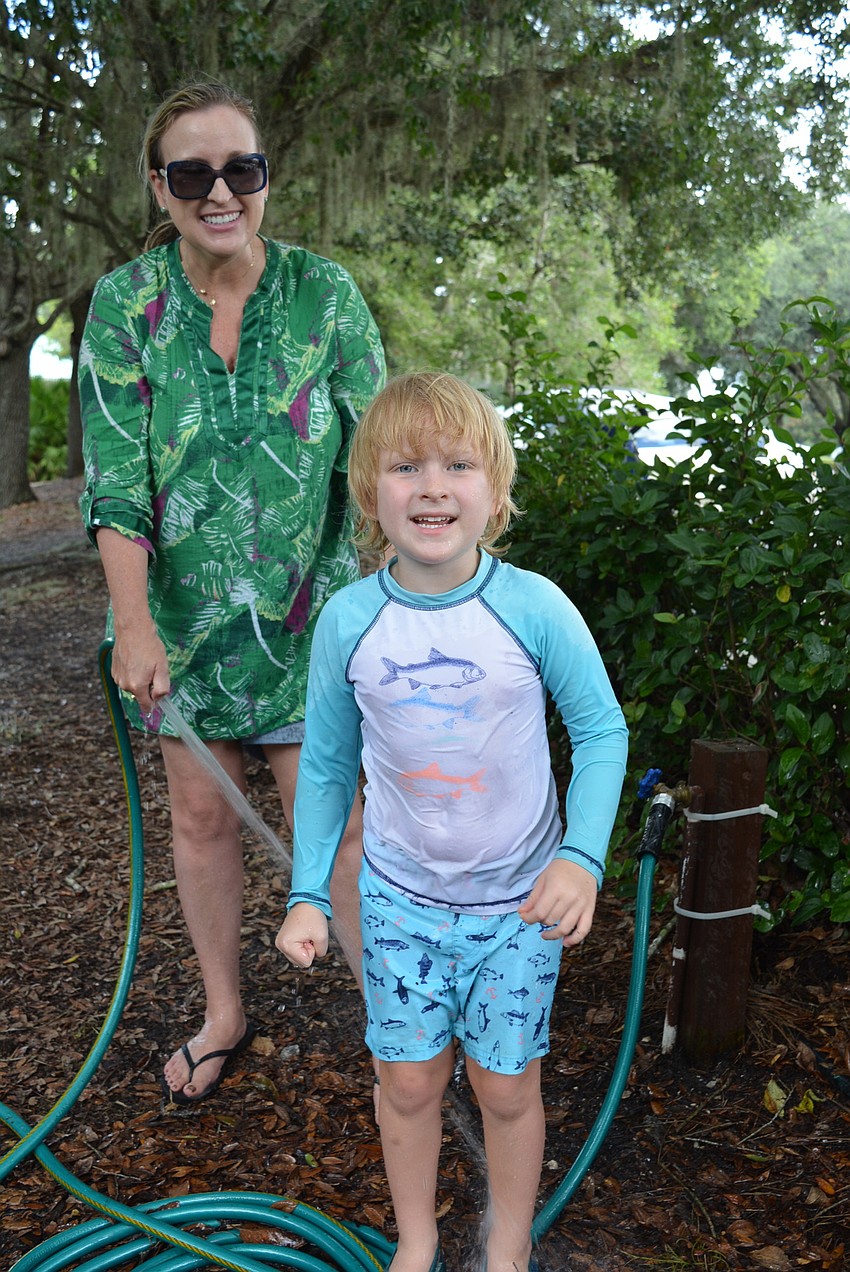 Jennifer Eubanks hoses off her 5-year-old son, Mark Eubanks, to clean up after playing at the park.