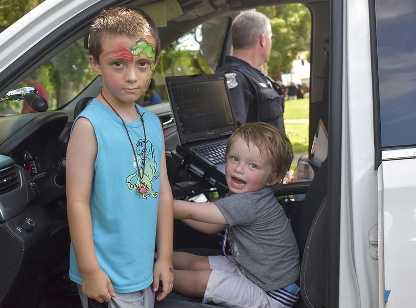 Chase, 5, and Cooper McCann, 2, test out one of the Sarasota patrol cars.