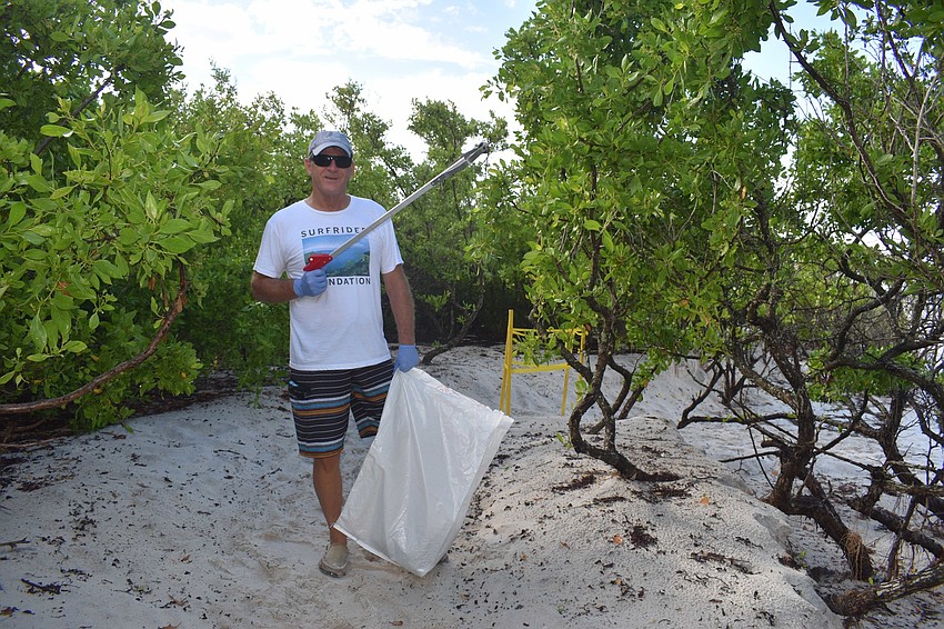 John Kurz dresses to impress with a Surfrider shirt and trash grabber.