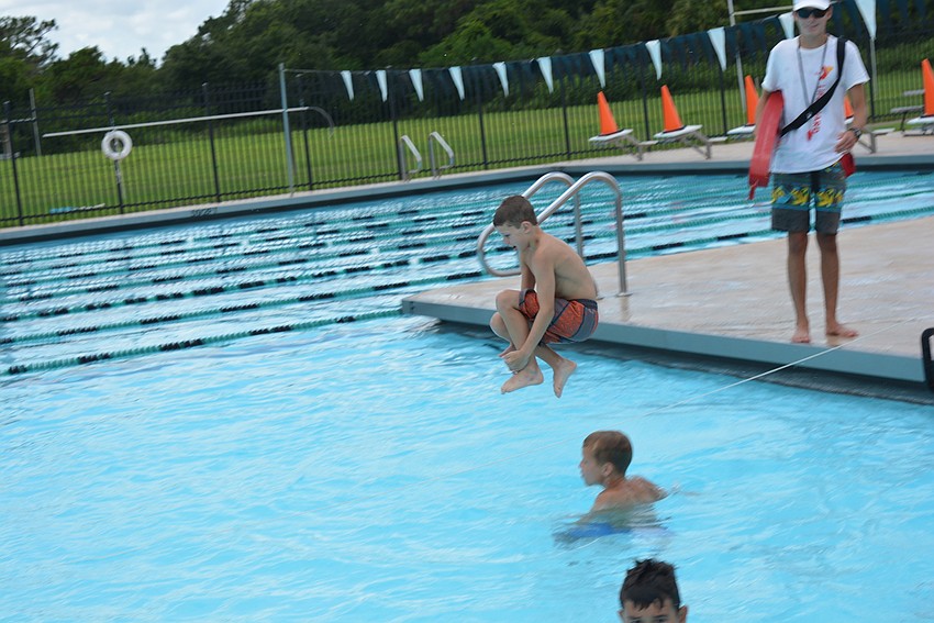 Ten-year-old Nicholas Rogers perfects his cannon ball jump before cardboard boat racers take over the pool.
