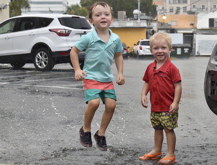 Jack and James Sherk play in a rain puddle during the festival.