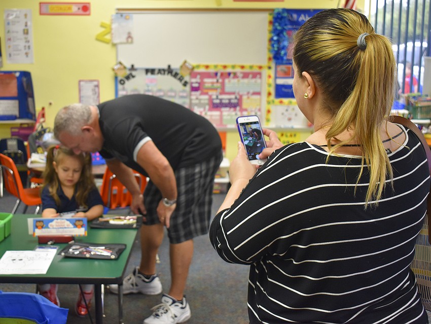 Yenisbel Fernandez snaps a photo of Pablo and Natalie Velazquez before her first class at Gocio Elementary School. // Whitney Elfstrom
