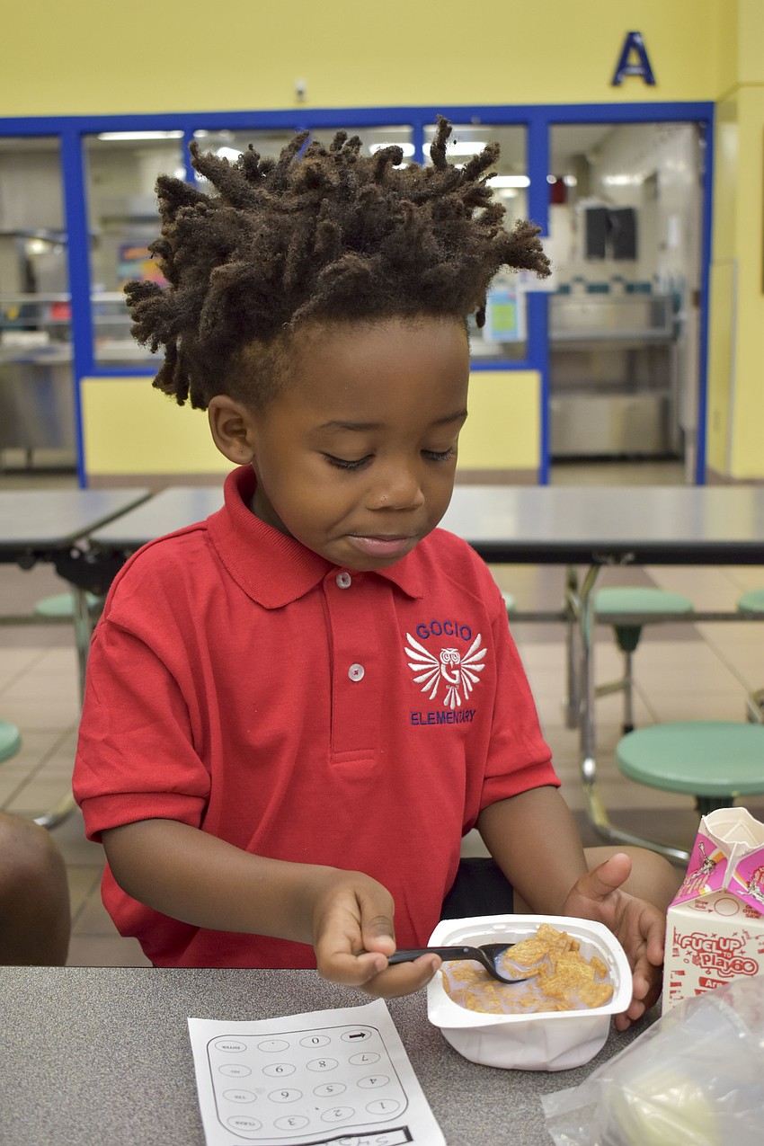 Rokhi Williams munches on cereal in the Gocio Elementary School cafeteria before his first day of kindergarten. // Whitney Elfstrom