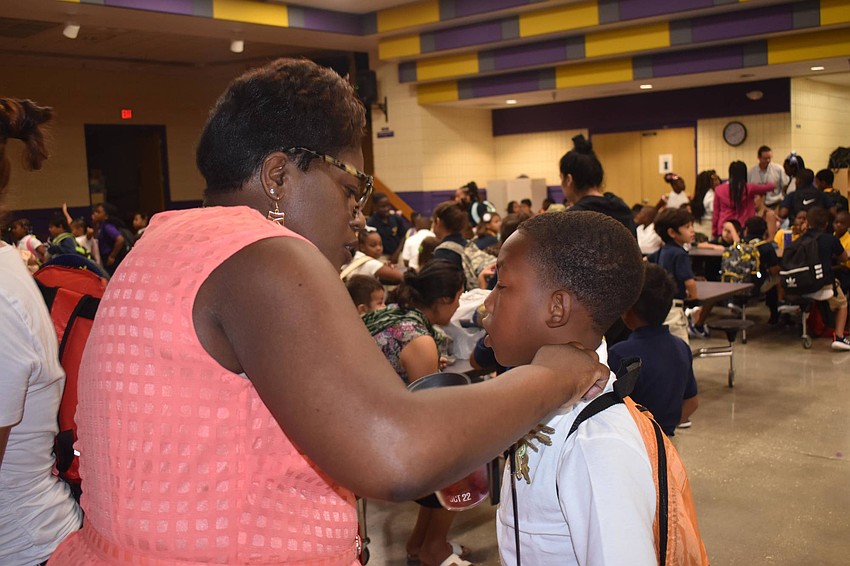 Emma E. Booker Elementary Principal Edwina Oliver straightens a students collar. // Nathalie Kaemmerer