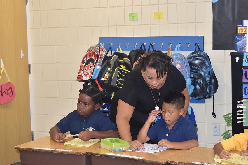 Johanna Caminero helps Jaime Tomas-Jacinto with a worksheet at Emma E. Booker Elementary. // Nathalie Kaemmerer