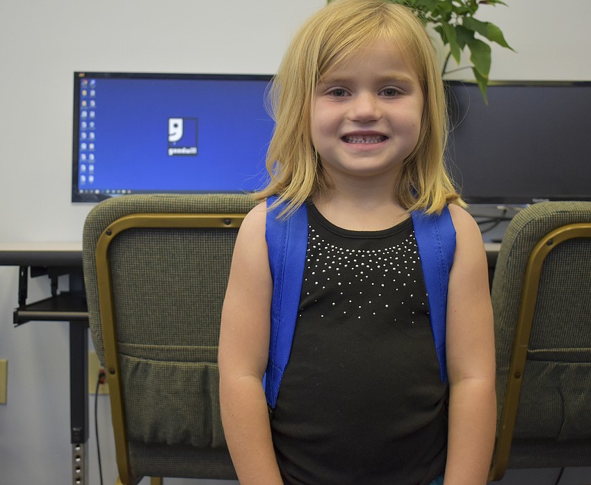 Adalene Bailey, 6, picks out a blue backpack.