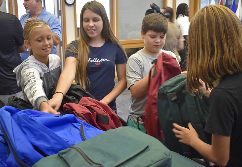 Izzie Landis, Bailey Hughes, Xavier Hughes and Gabi Landis pick out their backpacks.