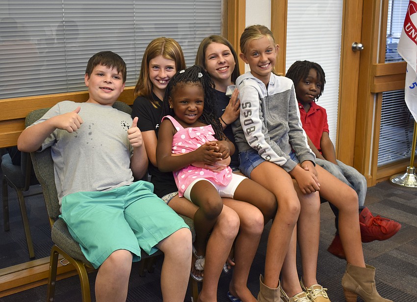 The kids hang out before they pick out their backpacks.
