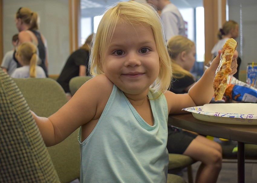 Victoria Aryes, 3, munches on her cheese pizza.