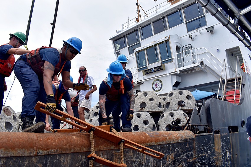 Coast Guard crew members help Eternal Reef employees onto the Joshua Appleby.