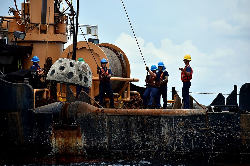 U.S. Coast Guard members help place the reef balls on the ocean floor.