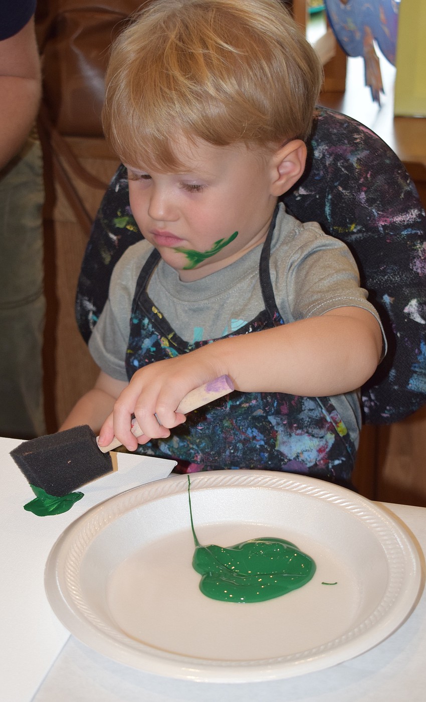 Lakewood Ranch 2-year-old Palmer Naumann works on his art, and paints his face at the same time.