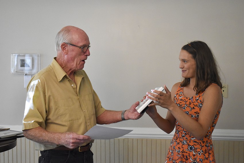 Dick Miles receives a dedication award from Kylie Wilson for working almost every day of the nesting season on Siesta Beach.