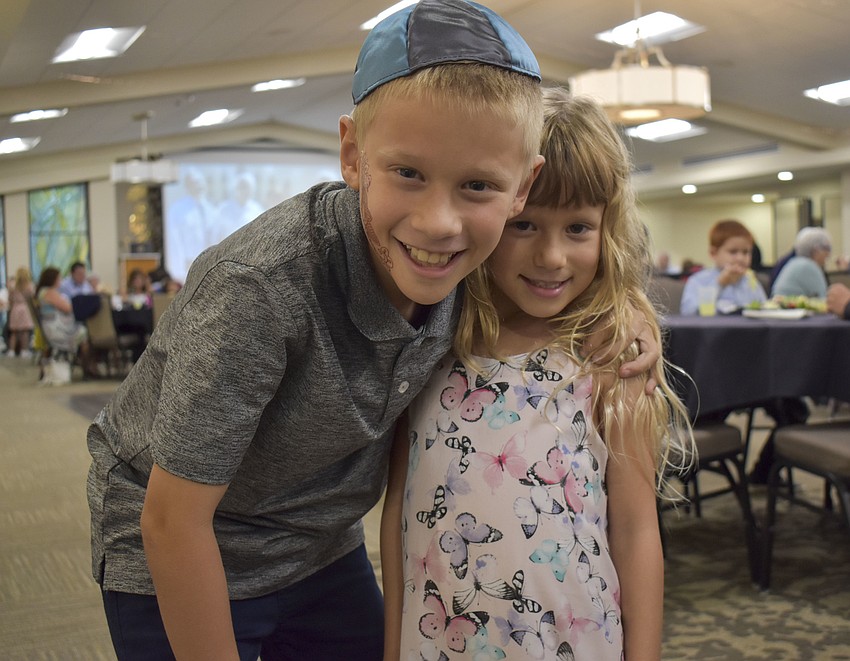 Zach, 9, and Raina Kurnov, 6, pose after getting henna tattoos.