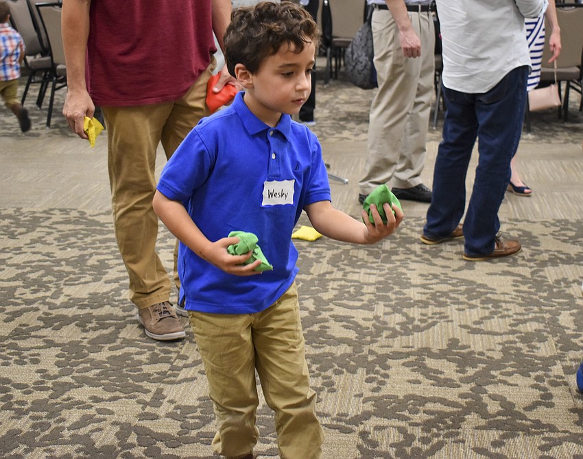 Wesley Wolff, 6, makes a toss during a bean bag game.