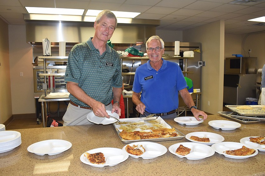 Tom Cleveland and Bill Wartinbee serve up the fish filets.