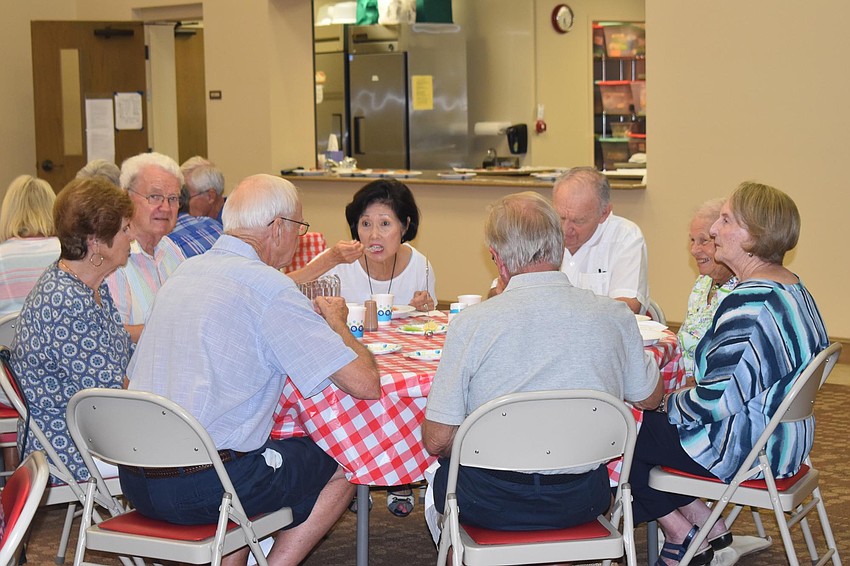 A full table chats together during dinner.