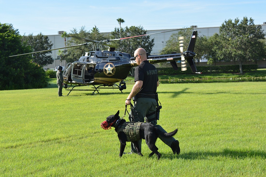 K-9 department dog Ron, and his handler, Jerod Wolfe , prepare to get onto the helicopter for transport during a training exercise Aug. 20.