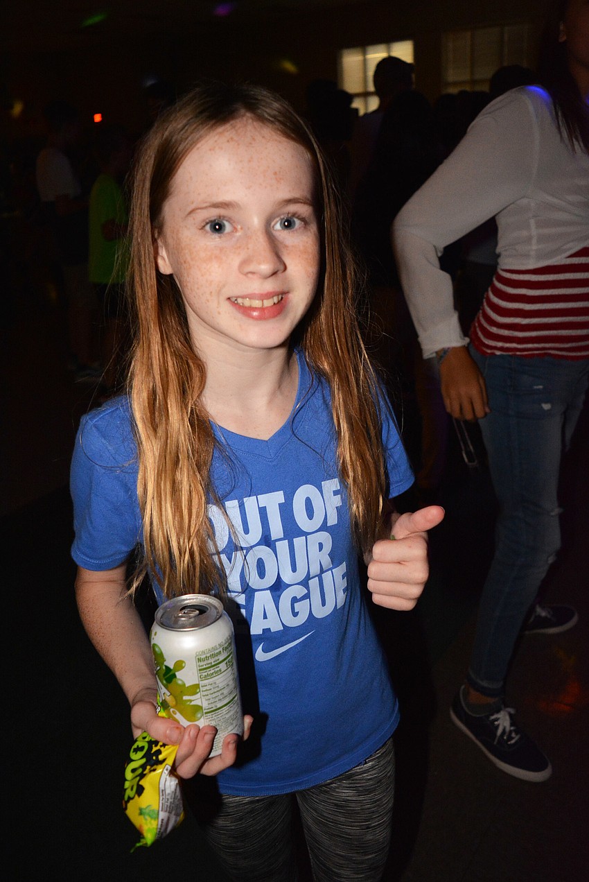 Sixth-grader Leah Erhardt catches up with friends after grabbing pizza and a snack.