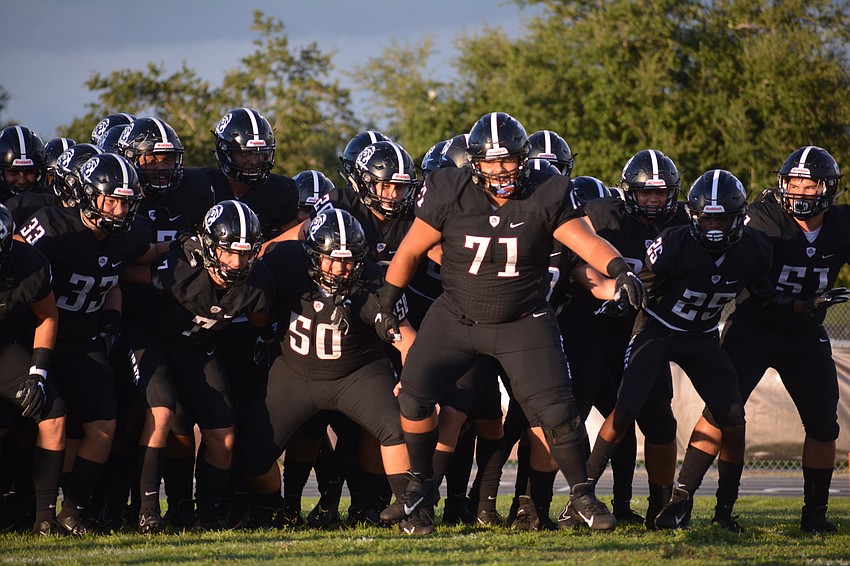 Senior offensive lineman Diego Aviles (71) leads the team onto the field.