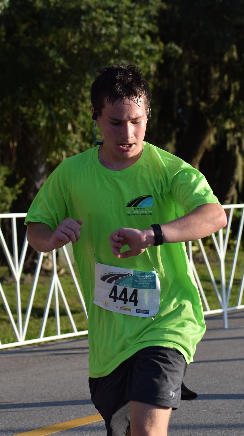 Lakewood Ranch resident Nate Bentze crosses the finish line during the Fort Hamer Bridge Run Saturday.