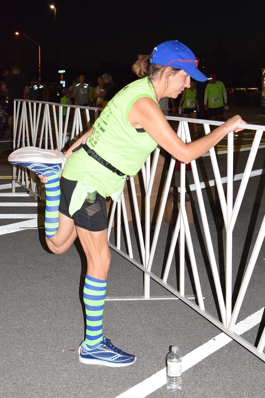 Trinity resident Chrysta Gyoerkoes stretches to prepare for her race during the Fort Hamer Bridge Run Saturday.